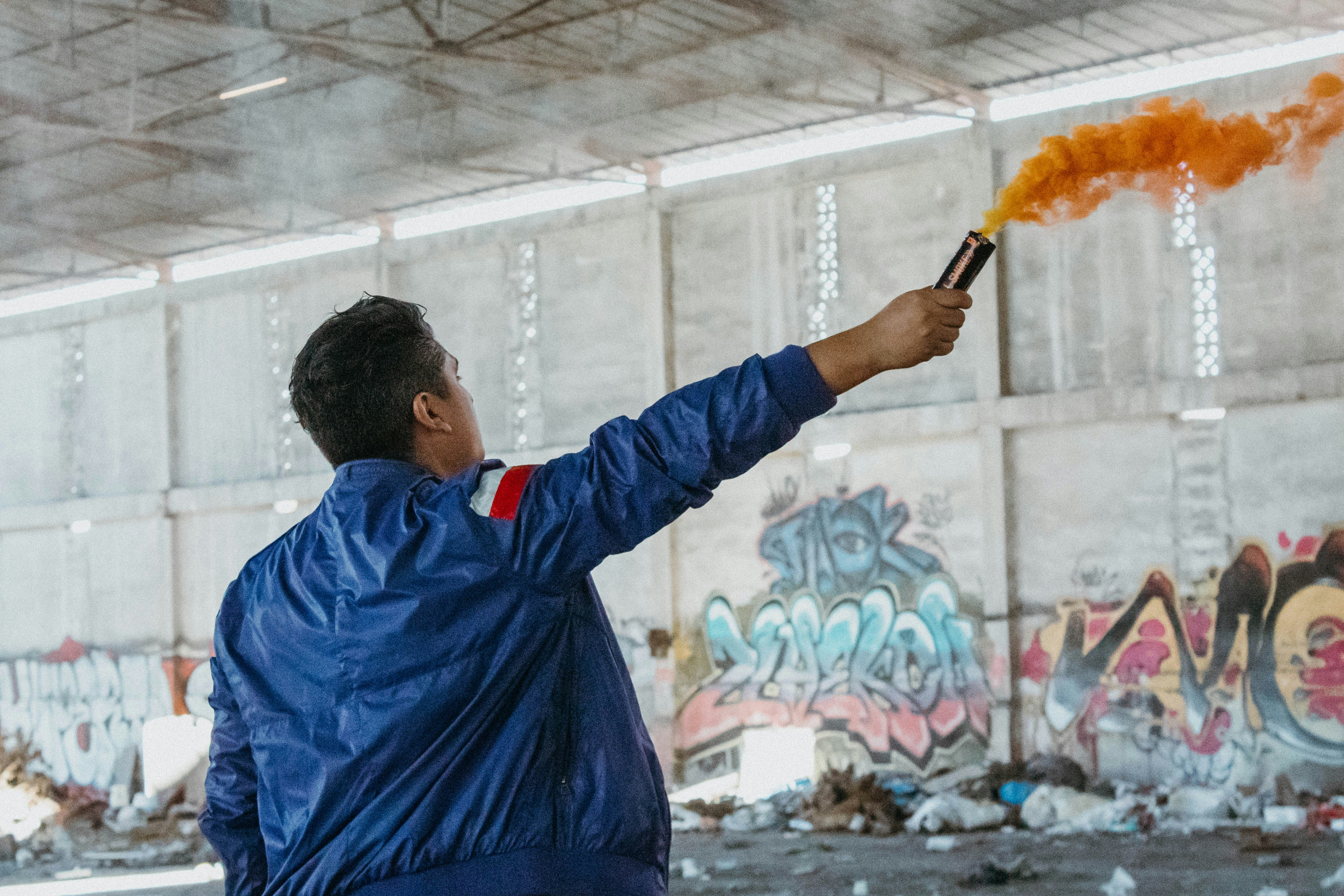 man in blue jacket holding orange powder